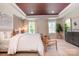 Elegant main bedroom showcasing a tray ceiling, wooden floors, and many windows at 7930 Rolling Wheels Rd, Charlotte, NC 28215