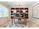 Bright home office with custom built-in shelving, modern desk, and large window for natural light at 7930 Rolling Wheels Rd, Charlotte, NC 28215