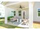 Covered patio with neutral toned seating area, ceiling fan, rug and outdoor lighting at 7930 Rolling Wheels Rd, Charlotte, NC 28215