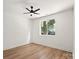 Simple bedroom featuring light-colored floors, a modern ceiling fan, and a bright window at 8632 Cedarbrook Dr, Charlotte, NC 28215