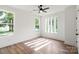Bright, spacious bedroom with a ceiling fan, large window, and light-colored flooring at 8632 Cedarbrook Dr, Charlotte, NC 28215