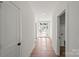 Bright entryway featuring hardwood floors, white walls, and a modern glass front door at 8632 Cedarbrook Dr, Charlotte, NC 28215