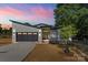 Beautiful modern home exterior with black trim, sleek garage door, and a well-manicured lawn at sunset at 8632 Cedarbrook Dr, Charlotte, NC 28215