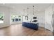 Well-lit kitchen with a navy island, stainless appliances, modern pendants, and bright white cabinets at 8632 Cedarbrook Dr, Charlotte, NC 28215