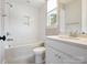 Bathroom featuring a shower-tub combo, white cabinets, a marble countertop, and a window at 1008 Ladera Dr, Waxhaw, NC 28173