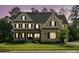 Charming two-story home featuring a stone facade, covered porch, and manicured lawn at 1008 Ladera Dr, Waxhaw, NC 28173