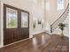 Grand foyer boasting a soaring ceiling, dark hardwood floors, elegant staircase, and a striking entry door at 1008 Ladera Dr, Waxhaw, NC 28173
