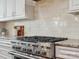 Modern kitchen with stainless steel range and granite countertops, complemented by sleek white cabinetry at 1008 Ladera Dr, Waxhaw, NC 28173