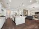 Open kitchen with granite island, stainless appliances, and seamless flow to living area with stone fireplace at 1008 Ladera Dr, Waxhaw, NC 28173
