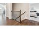 Stairway with wood steps and flooring, a dark metal railing, and white baseboards and trim at 1008 Ladera Dr, Waxhaw, NC 28173