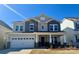 Charming two-story home with a welcoming front porch, a two-car garage, and beautiful architectural details at 1025 Puddle Pond Rd, Indian Trail, NC 28079