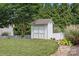 Backyard view of a storage shed with double doors surrounded by well-maintained landscaping at 112 Artisan Ct, Mooresville, NC 28117
