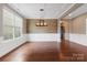 Elegant dining room featuring a wood accent wall, wainscoting, modern lighting, and hardwood flooring at 112 Artisan Ct, Mooresville, NC 28117