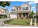 Beautiful two-story home with a well-manicured lawn, stone accents, and a two-car garage at 112 Artisan Ct, Mooresville, NC 28117