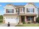 Charming two-story home with stone accents, a two-car garage, and a welcoming front porch at 112 Artisan Ct, Mooresville, NC 28117