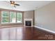 Spacious living room featuring hardwood floors, a fireplace, and large windows for ample light at 112 Artisan Ct, Mooresville, NC 28117