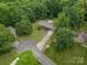 An aerial shot showing a home surrounded by trees and landscaping on a large lot with a long driveway at 1142 Foxberry Rd, Lincolnton, NC 28092