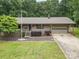 A single-story home with an attached garage and a covered front porch is complemented by lush landscaping at 1142 Foxberry Rd, Lincolnton, NC 28092