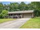 Charming single-story home featuring a front porch, attached garage, and a well-maintained lawn with mature trees at 1142 Foxberry Rd, Lincolnton, NC 28092