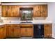 Kitchen features wood cabinets, window over sink, and black dishwasher at 1142 Foxberry Rd, Lincolnton, NC 28092
