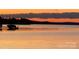 A sunset view of the lake with a boat lift, and silhouettes of trees against a colorful sky at 14515 Nc Hwy 73 Hwy, Huntersville, NC 28078