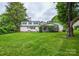 Spacious backyard featuring a lush green lawn, mature trees, and a charming two-story home at 1506 Cameron Dr, Statesville, NC 28625