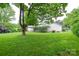 Large, lush backyard with mature trees surrounding a two-story home with white siding at 1506 Cameron Dr, Statesville, NC 28625