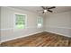 Bright bedroom features hardwood floors, neutral walls, ceiling fan, and two windows at 1506 Cameron Dr, Statesville, NC 28625