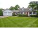 Charming single-Gathering home featuring a lush green lawn, bright red front door, and manicured landscaping at 1506 Cameron Dr, Statesville, NC 28625