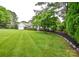 Beautifully landscaped front yard with a lush green lawn and mature shade tree at 1506 Cameron Dr, Statesville, NC 28625