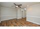 Spacious living room with hardwood floors, neutral walls, ceiling fan, and access to hallway at 1506 Cameron Dr, Statesville, NC 28625