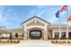 Elegant clubhouse entrance featuring stone accents, glass doors, and manicured landscaping for a welcoming first impression at 17436 Hawks View Dr, Indian Land, SC 29707