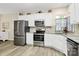 Bright kitchen with stainless steel appliances, white cabinetry, granite countertops, and wood floors at 17436 Hawks View Dr, Indian Land, SC 29707
