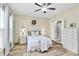 Bright bedroom with wood-look floors, ceiling fan, white trim, and ensuite bathroom at 17436 Hawks View Dr, Indian Land, SC 29707