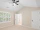 Neutral bedroom with vaulted ceiling, bright window with white shutters and view to an ensuite bathroom at 18840 Silver Quay Dr # 12, Cornelius, NC 28031