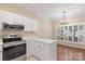 Eat-in kitchen featuring white cabinetry, stainless steel appliances, and a modern chandelier at 18840 Silver Quay Dr # 12, Cornelius, NC 28031