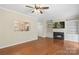 Spacious living room with hardwood floors, fireplace, built-in shelving, and a view into the kitchen at 18840 Silver Quay Dr # 12, Cornelius, NC 28031