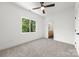 A carpeted bedroom featuring a ceiling fan, window view, and an ensuite bathroom with a walk-in shower at 2004 St John St, Charlotte, NC 28216