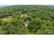 Aerial view of a secluded home surrounded by dense trees and featuring a backyard pool at 2006 Sandy Pond Ln, Waxhaw, NC 28173