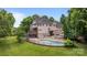 Beautiful backyard showcasing a pool, a spacious deck, and lush landscaping at 2006 Sandy Pond Ln, Waxhaw, NC 28173