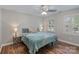 Bedroom with wood floors, two windows, a ceiling fan, and a bed with lamps on side tables at 2006 Sandy Pond Ln, Waxhaw, NC 28173