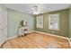 Bedroom features wood floors, windows with plantation shutters, and a vintage vanity with a stool at 2006 Sandy Pond Ln, Waxhaw, NC 28173