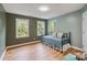 Bedroom features wood floors, three windows, and blue walls at 2006 Sandy Pond Ln, Waxhaw, NC 28173