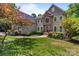 Stunning home showcasing a stone facade, manicured lawn, mature landscaping and a charming walkway leading to the front door at 2006 Sandy Pond Ln, Waxhaw, NC 28173