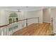 Second-floor landing showcasing hardwood floors, a large window, and white railing overlooking the foyer at 2006 Sandy Pond Ln, Waxhaw, NC 28173