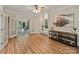 Open living room showcasing hardwood floors, double doors to a sunroom, and views of the backyard at 2006 Sandy Pond Ln, Waxhaw, NC 28173