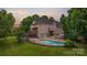 Stunning rear exterior view of a multi-story home featuring a pool, deck, and lush landscaping at 2006 Sandy Pond Ln, Waxhaw, NC 28173