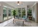 Bright sunroom featuring multiple windows, tile flooring, neutral furniture, and a charming electric fireplace at 2006 Sandy Pond Ln, Waxhaw, NC 28173