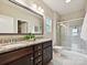 Bathroom features double vanity with granite countertop, framed mirror, and glass-enclosed shower at 2017 New Hope Branch Way, Belmont, NC 28012