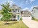 Charming two-story home with a well-manicured lawn, a two car garage, and a welcoming front porch at 2017 New Hope Branch Way, Belmont, NC 28012